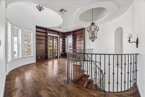 a bedroom with a large bed chandelier and a window