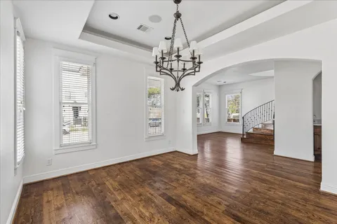 a view of a livingroom with wooden floor and a chandelier
