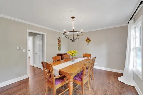 a dining room with furniture a chandelier and wooden floor