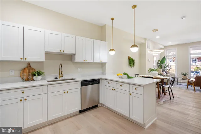 a kitchen with white cabinets and wooden floors