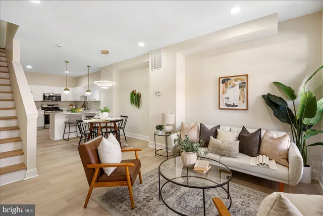 a living room with furniture kitchen and a potted plant