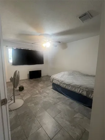 a bedroom with a bed and a flat screen tv