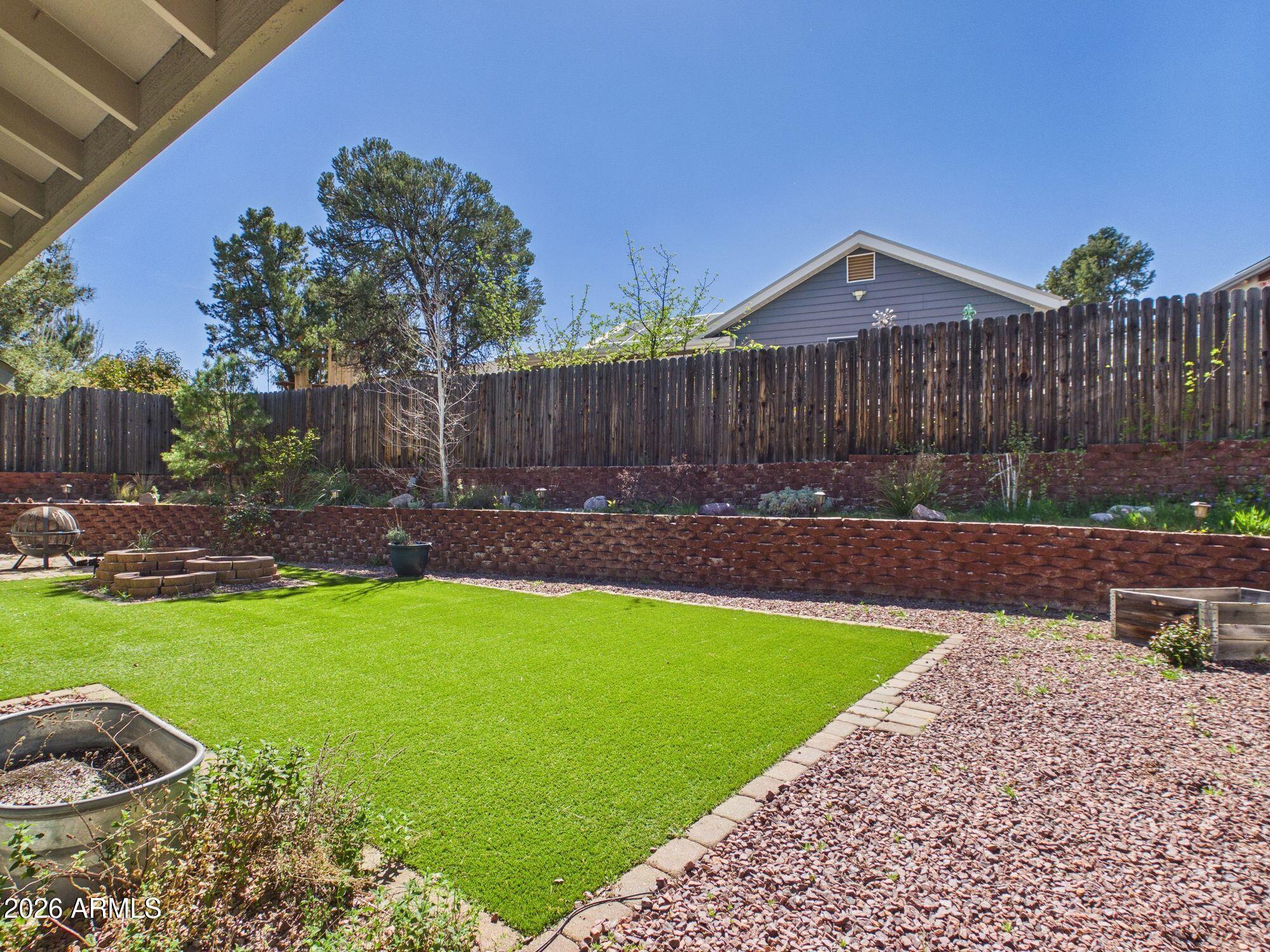 1104 North Rhone Circle Payson, AZ 85541 - Photo 24 of 39 a view of a backyard with a garden and wooden fence