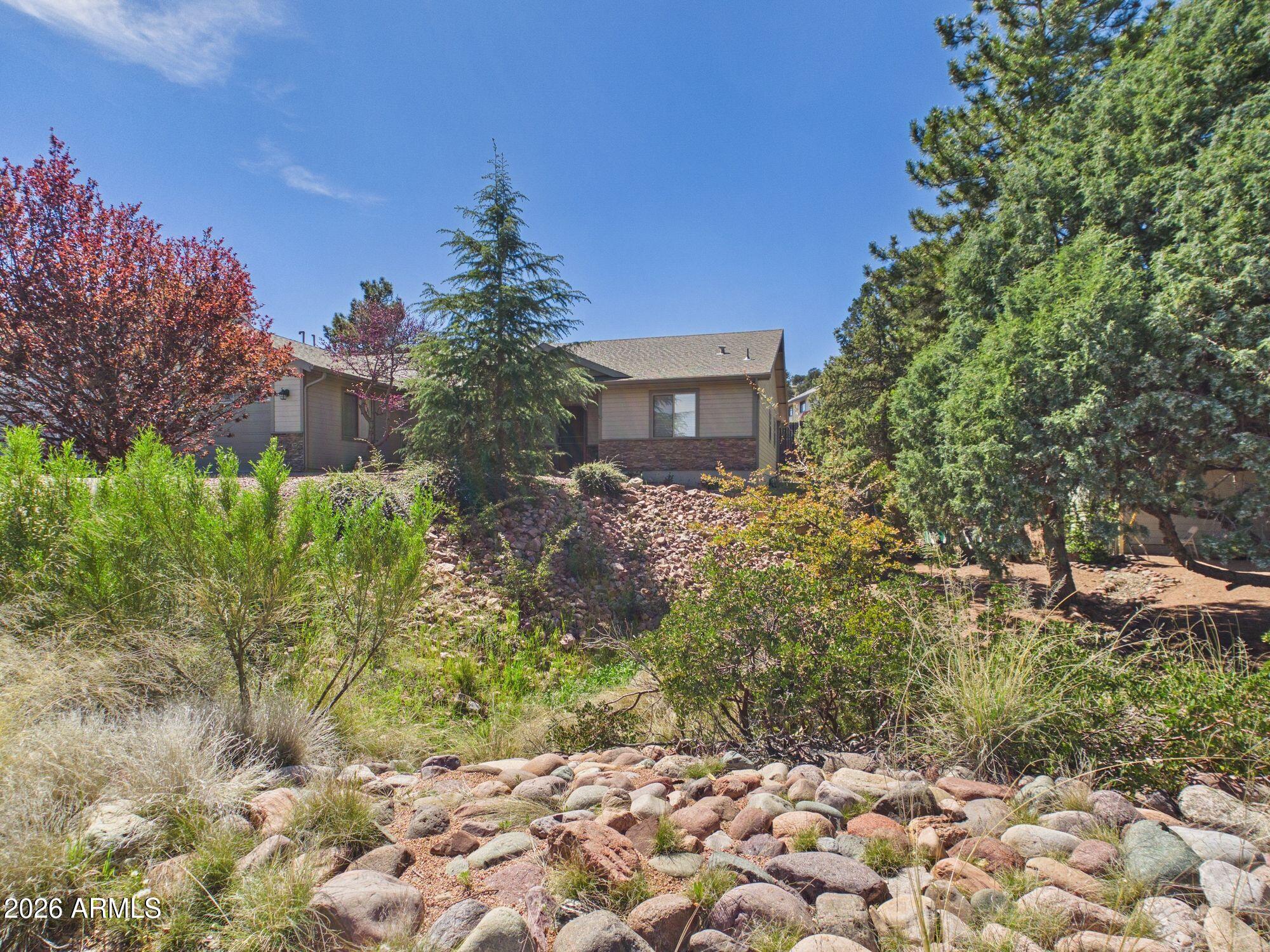1104 North Rhone Circle Payson, AZ 85541 - Photo 27 of 39 a flower garden in front of a house