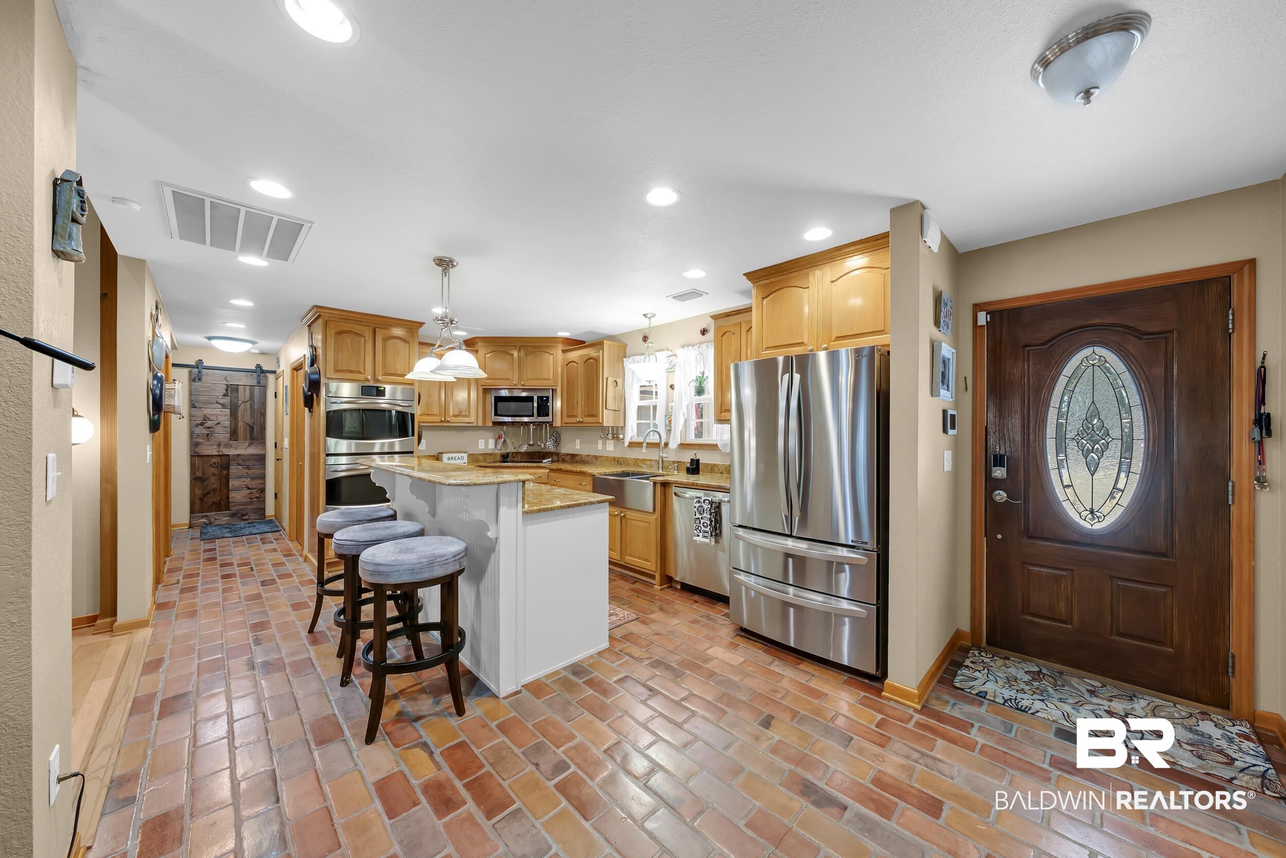 22929 Highway 98 Foley, AL 36535 - Photo 4 of 54 Kitchen featuring a breakfast bar, a barn door, stainless steel appliances, decorative light fixtures, and a center island
