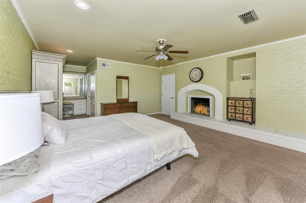 103 Robin Avenue Weatherford, TX 76086 - Photo 18 of 37 a spacious bedroom with a large bed and a chandelier