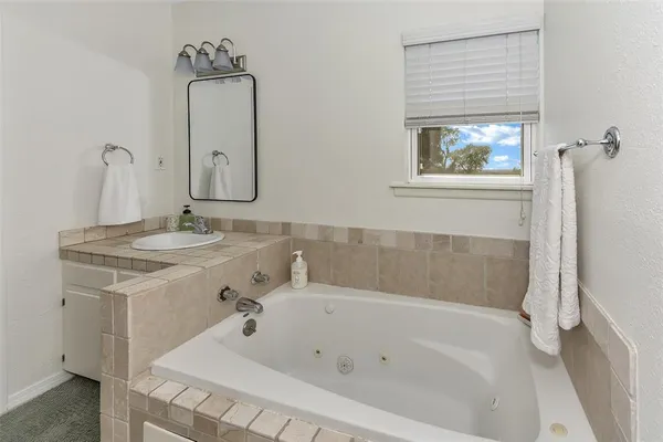 a spacious bathroom with a granite countertop sink a toilet and a large mirror