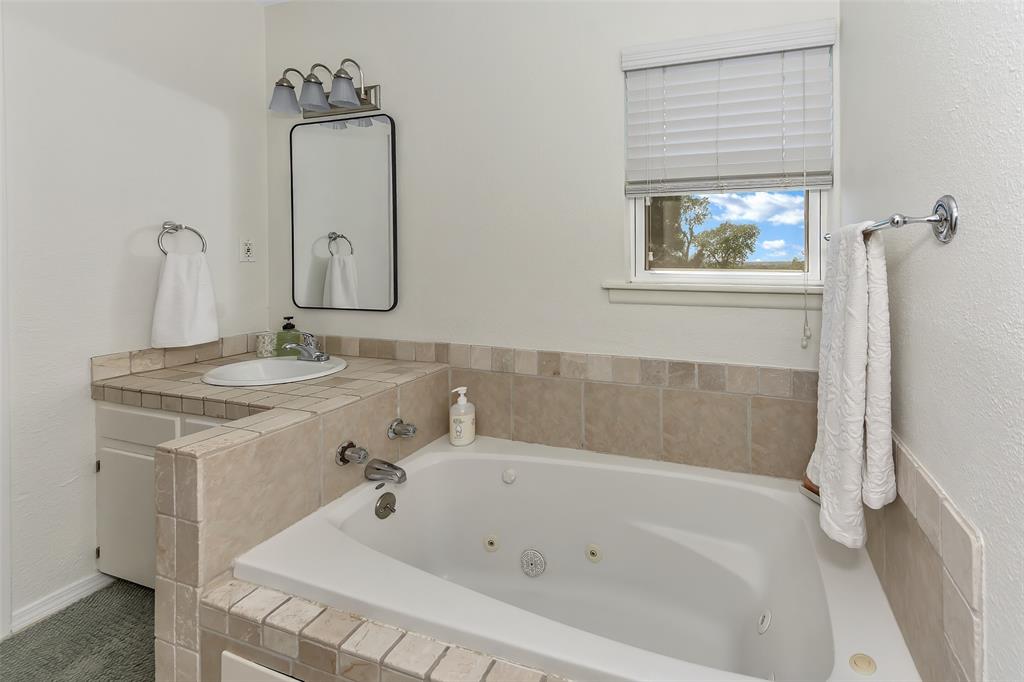 103 Robin Avenue Weatherford, TX 76086 - Photo 21 of 37 a bathroom with a tub sink and mirror