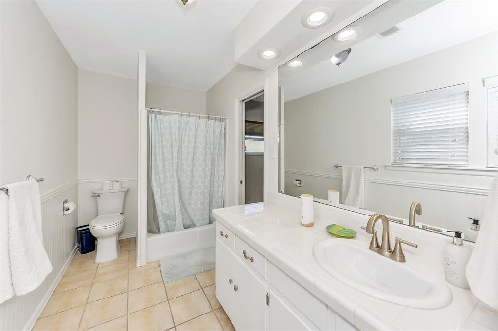 103 Robin Avenue Weatherford, TX 76086 - Photo 23 of 37 a spacious bathroom with a granite countertop sink a toilet and a large mirror