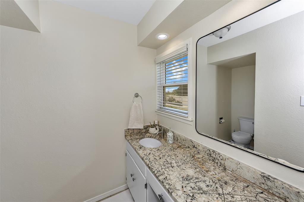 103 Robin Avenue Weatherford, TX 76086 - Photo 5 of 37 a bathroom with a granite countertop sink and a mirror