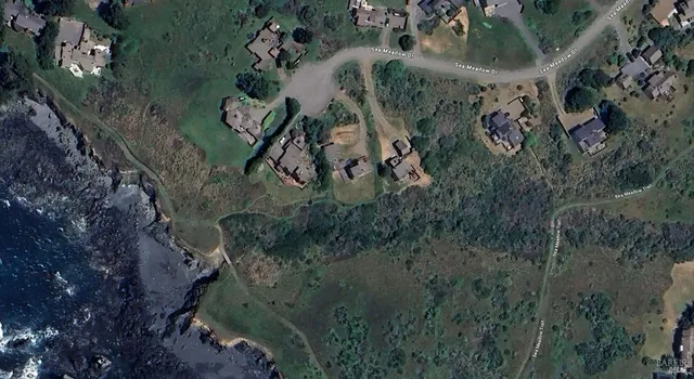 an aerial view of a house with a yard and mountain view