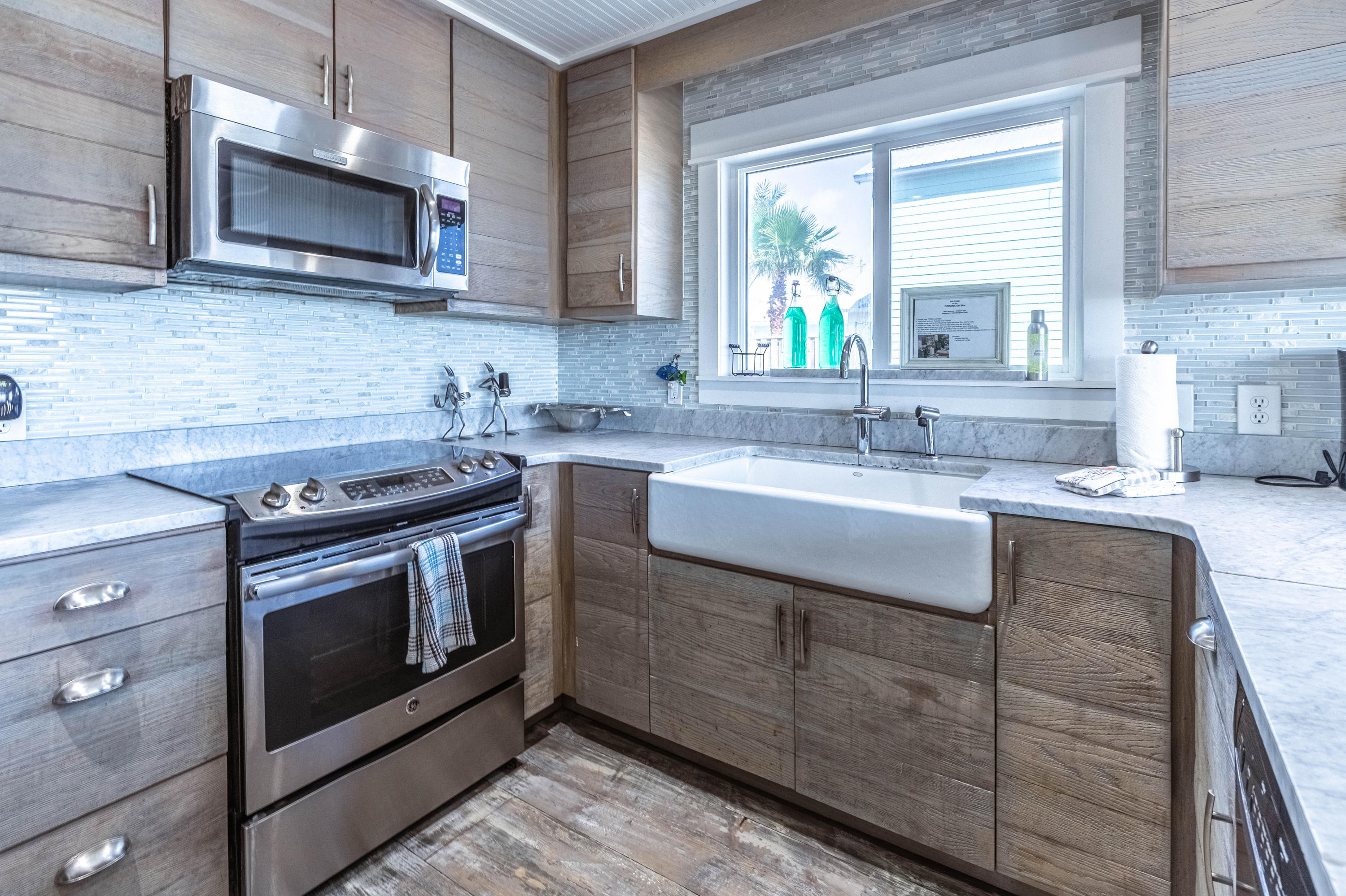 17807 Front Beach Road Panama City Beach, FL 32413 - Photo 8 of 17 a kitchen with stainless steel appliances granite countertop a stove a sink and a microwave