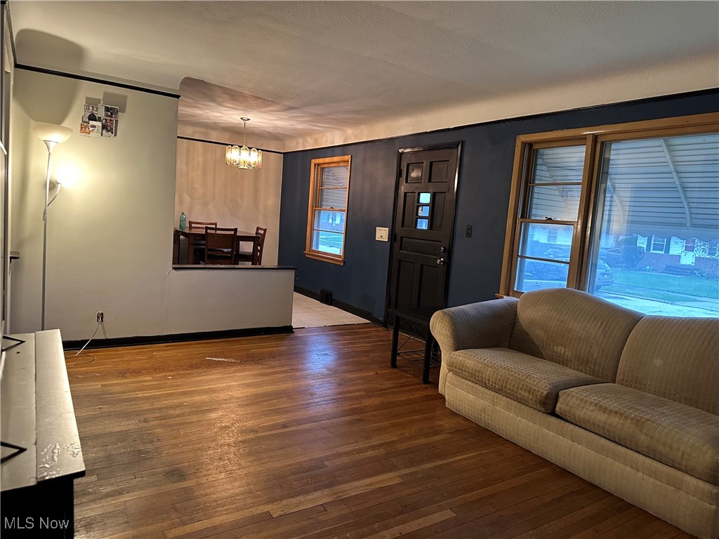12303 Orme Road Garfield Heights, OH 44125 - Photo 6 of 22 Living room with a wealth of natural light, a notable chandelier, baseboards, and wood finished floors