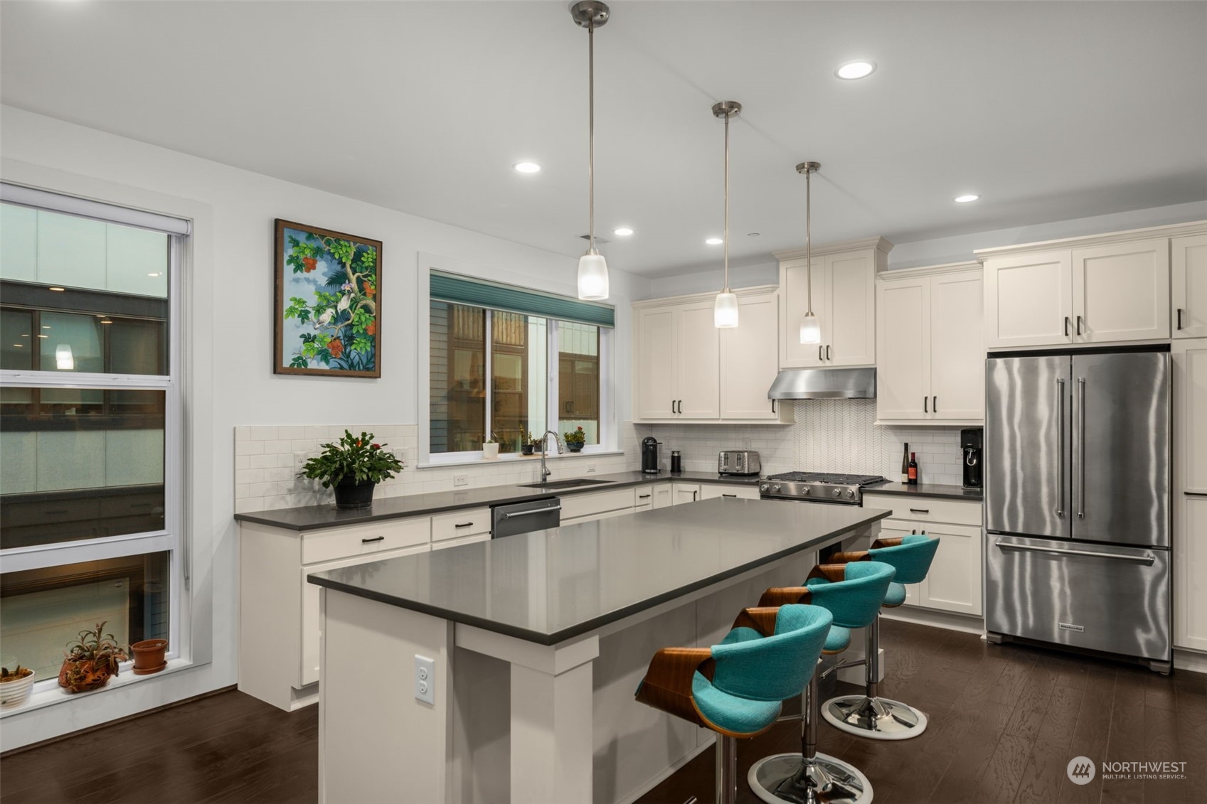 9604 Main Street, Unit B Bothell, WA 98011 - Photo 11 of 34 a kitchen with granite countertop stainless steel appliances a refrigerator a stove a sink cabinets and a dining table
