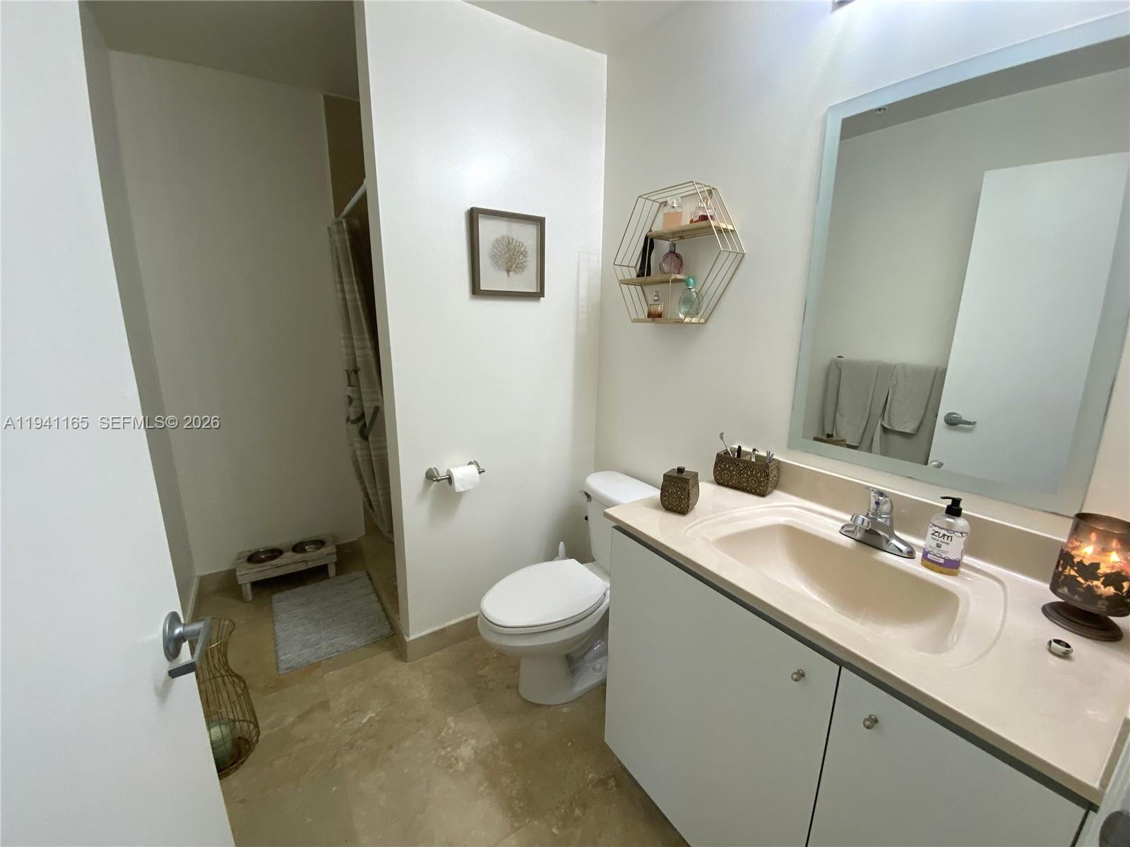 9066 Southwest 73rd Court, Unit 805 Miami, FL 33156 - Photo 9 of 33 a bathroom with a sink toilet and mirror