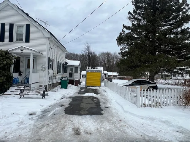 a view of swimming pool with outdoor seating and trees in the background