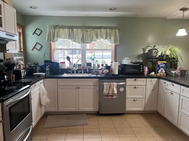 a kitchen with white cabinets and appliances