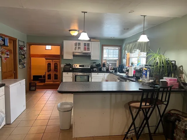 a kitchen with stainless steel appliances granite countertop a sink a stove and a wooden floors