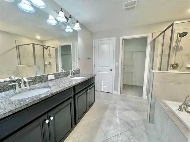 a bathroom with a granite countertop sink a large mirror and a shower