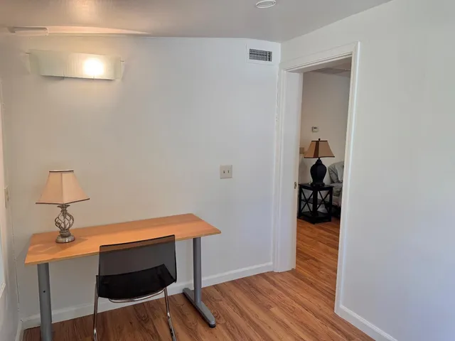 a view of a house with a yard and a large tree