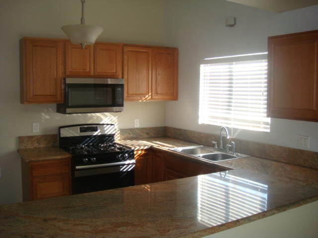 67235 Verona Road Cathedral City, CA 92234 - Photo 3 of 14 a kitchen with granite countertop a stove and a microwave