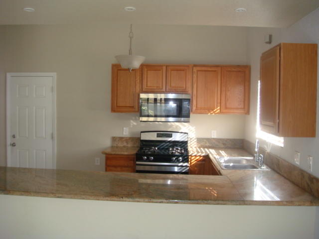67235 Verona Road Cathedral City, CA 92234 - Photo 4 of 14 a kitchen with granite countertop a stove and a refrigerator