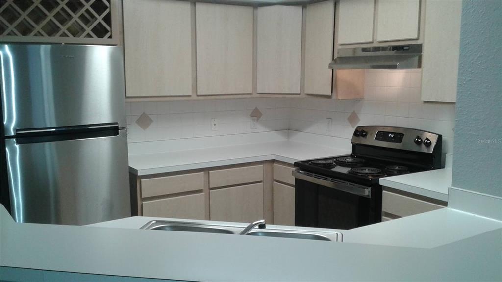 829 Camargo Way, Unit 203 Altamonte Springs, FL 32714 - Photo 15 of 26 a kitchen with a refrigerator stove and cabinets