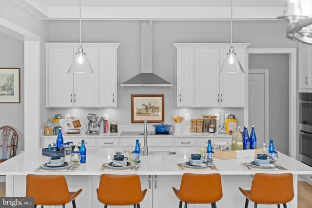 a kitchen with stainless steel appliances granite countertop a sink dishwasher and white cabinets with wooden floor