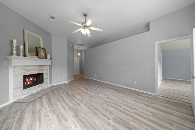 a view of empty room with wooden floor and fireplace