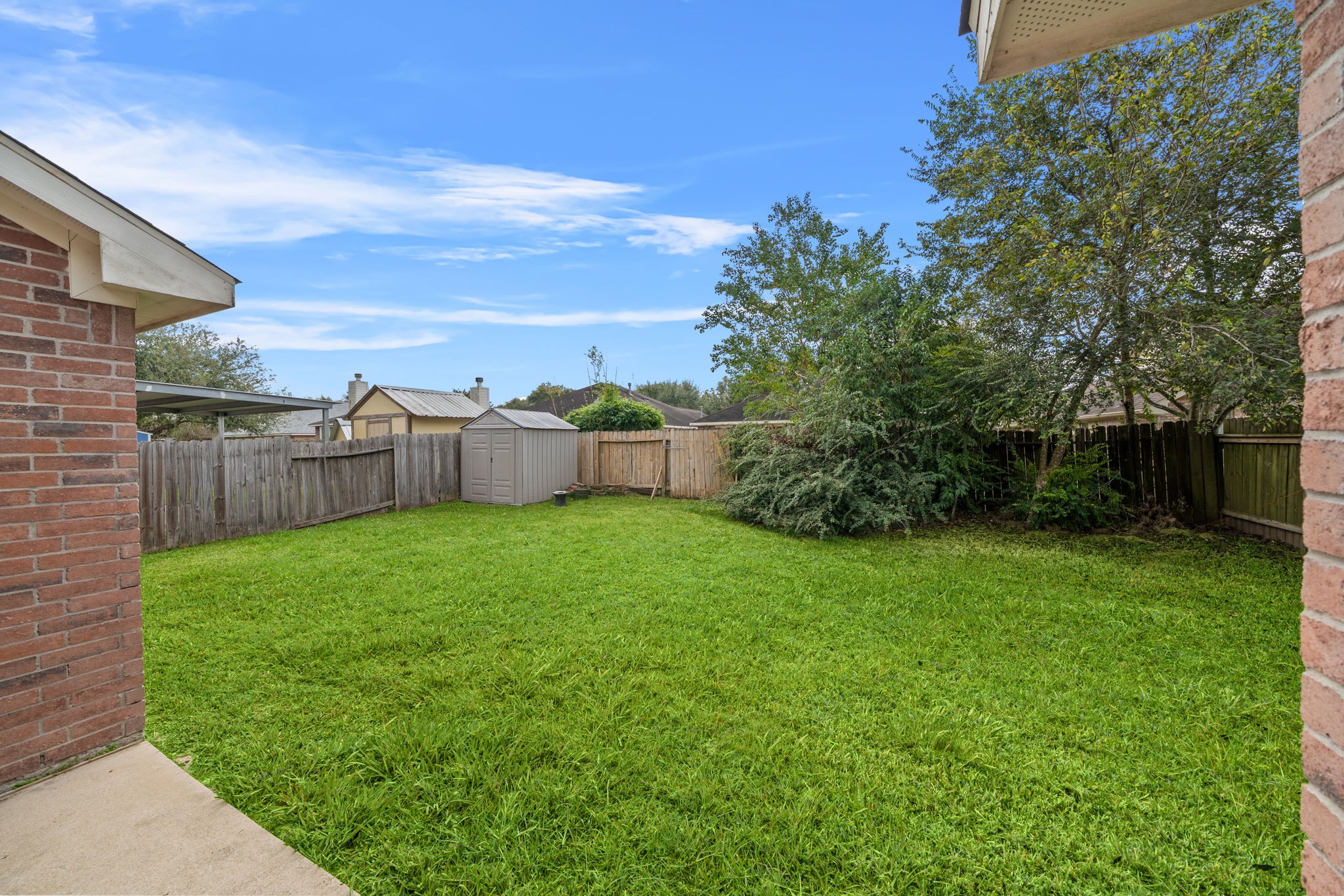694 St Croix Alvin, TX 77511 - Photo 26 of 30 a view of a backyard with grass and a large tree