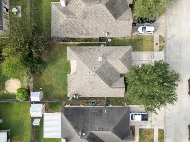 an aerial view of a house with a garden and lake view