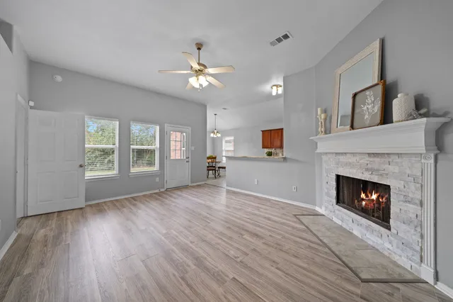 a view of empty room with wooden floor fireplace and windows