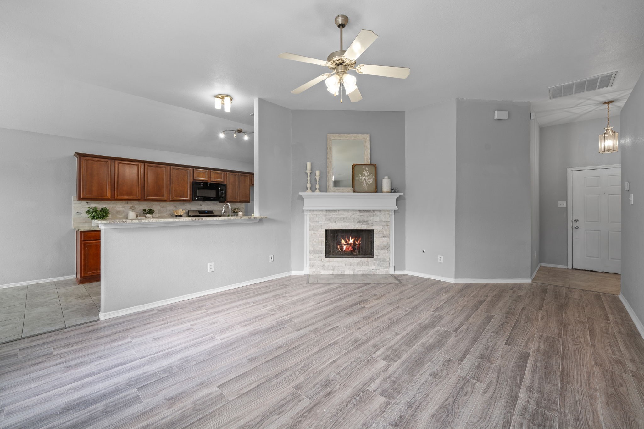 694 St Croix Alvin, TX 77511 - Photo 5 of 30 a view of kitchen and empty room with wooden floor and fan
