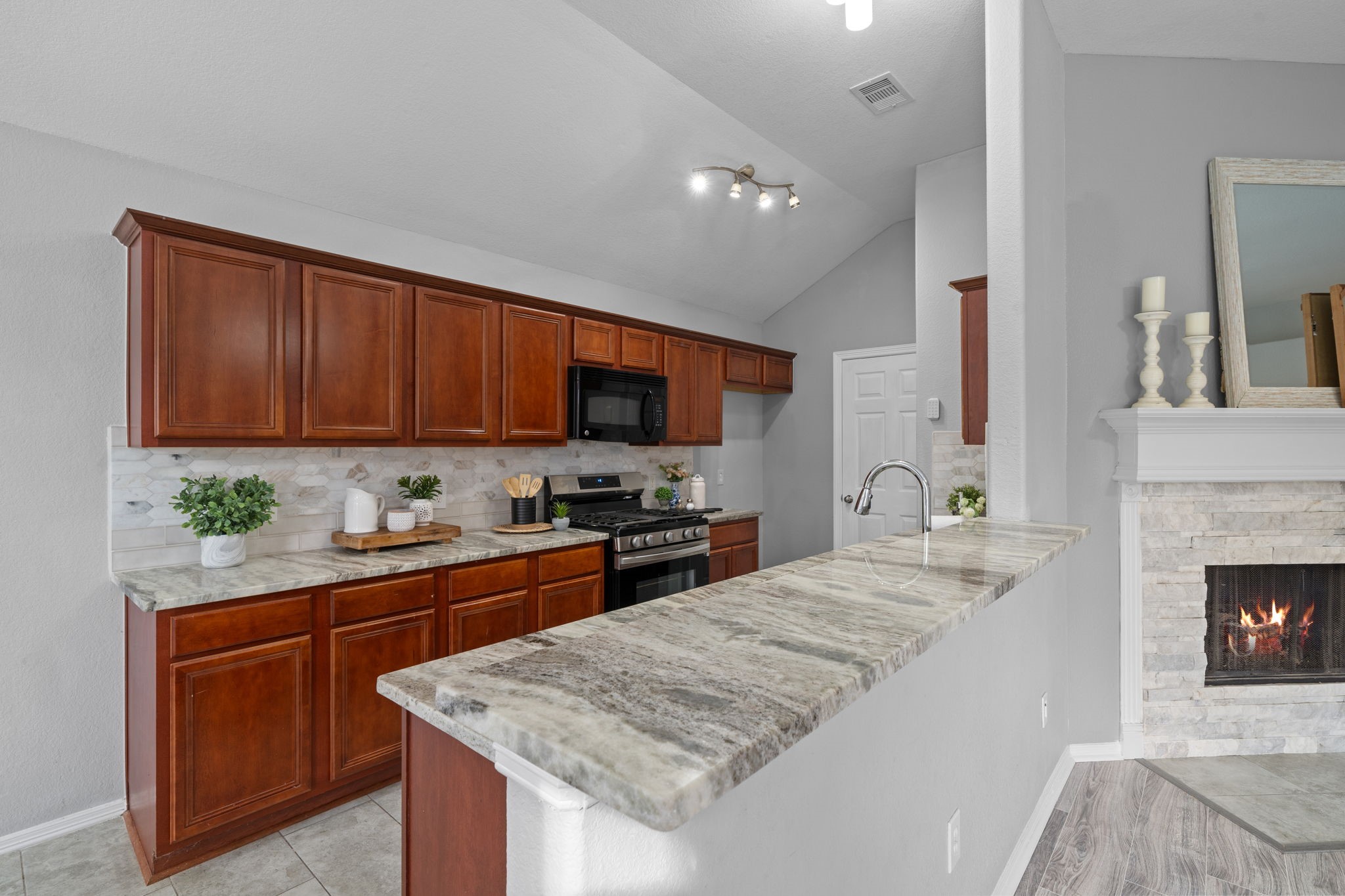 694 St Croix Alvin, TX 77511 - Photo 8 of 30 a kitchen with granite countertop wooden cabinets a stove top oven a sink and dishwasher