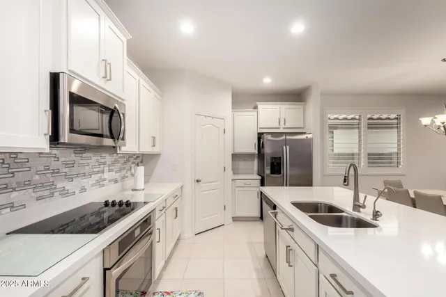 a kitchen with stainless steel appliances a sink stove microwave and refrigerator