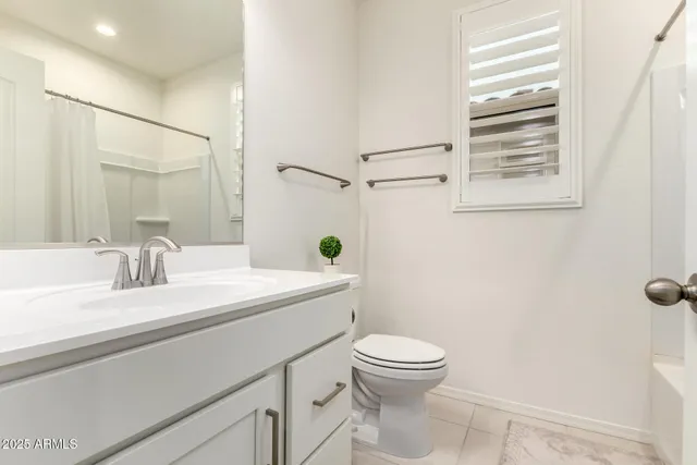 a bathroom with a granite countertop sink a toilet and a mirror