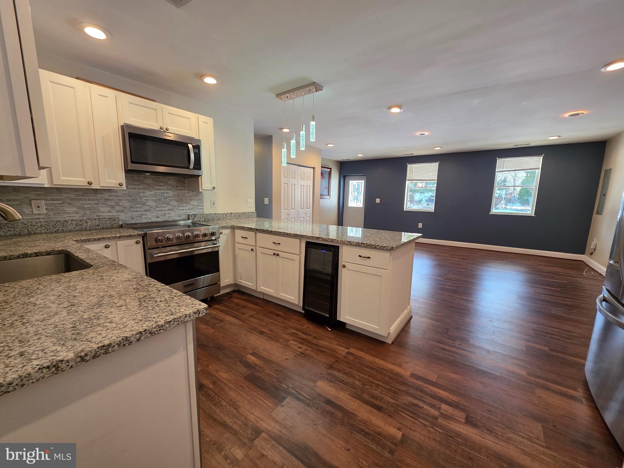 1342 Edna Road Pasadena, MD 21122 - Photo 13 of 31 a large kitchen with granite countertop a stove top oven a sink a counter space and cabinets
