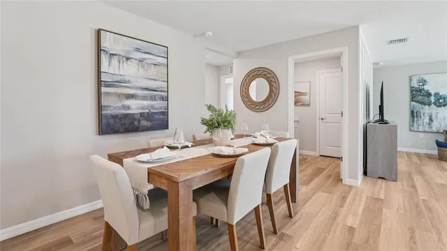 a dining room with a wooden table and chairs