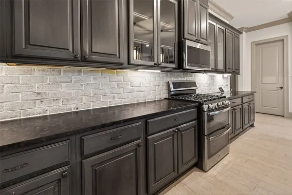 a kitchen with stainless steel appliances granite countertop a sink stove and microwave