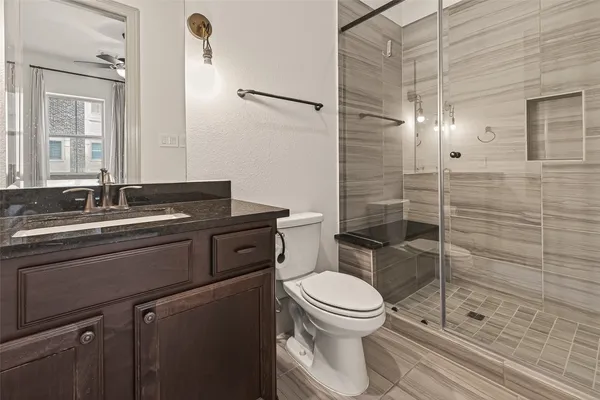 a bathroom with a granite countertop sink toilet and shower