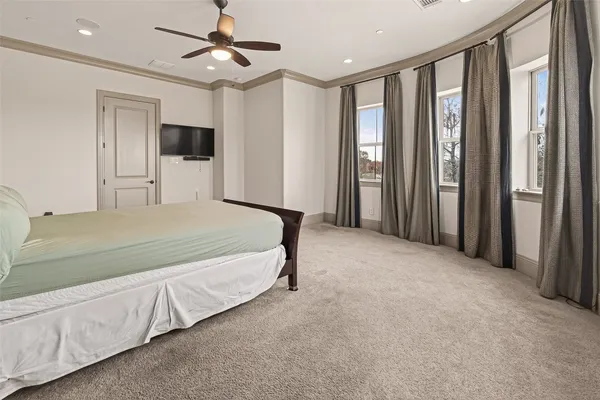 a spacious bedroom with a large bed and a chandelier