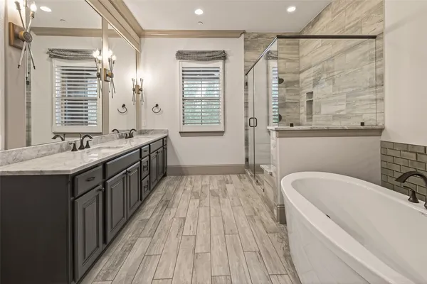 a spacious bathroom with a double vanity sink a mirror and a bathtub