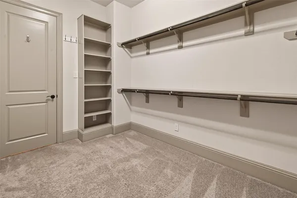 a view of walk in closet with empty racks