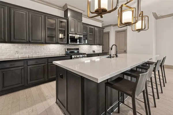 a kitchen with stainless steel appliances a sink a table and chairs