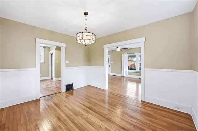 a view of empty room with wooden floor and window