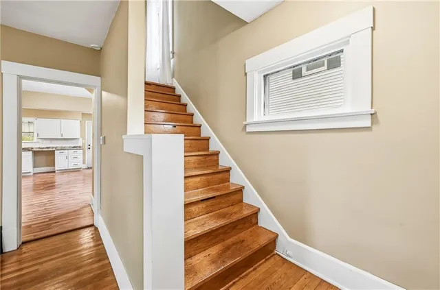 a view of a hallway with wooden floor and staircase