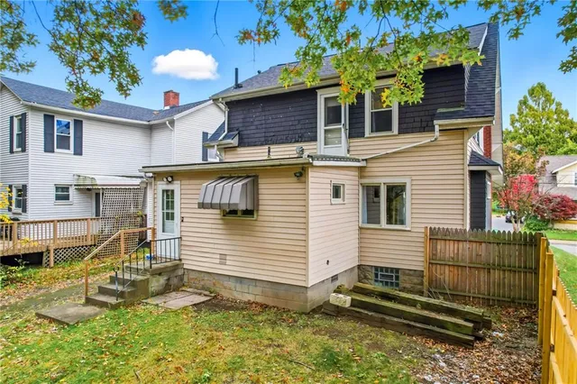 a view of a white house with a yard and potted plants