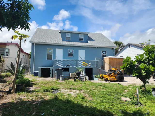 a view of a house with backyard sitting area and garden