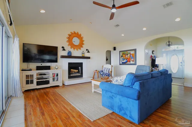 a living room with furniture kitchen view and a large window