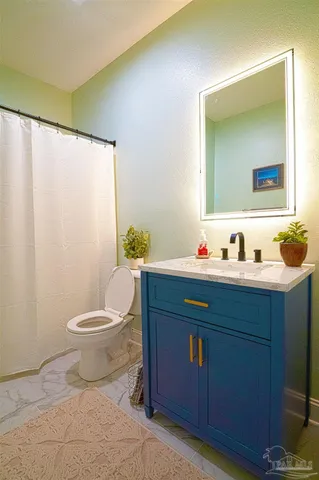 a bedroom with a bed a chair and a chandelier